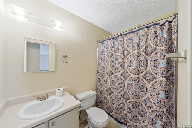 bathroom with toilet, vanity, a textured ceiling, and a shower with shower curtain