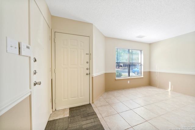 entryway featuring a textured ceiling and light tile patterned floors