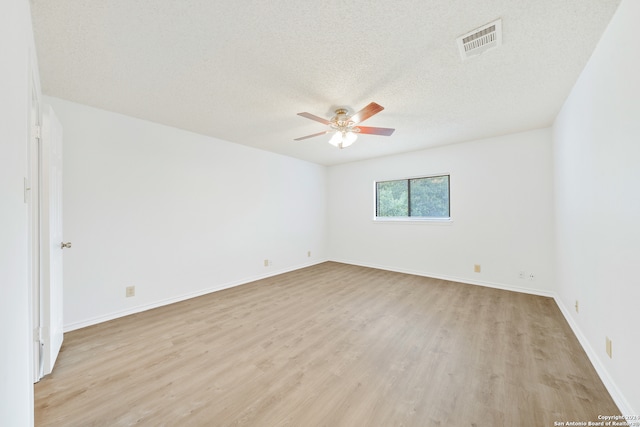 spare room with light wood-type flooring, a textured ceiling, and ceiling fan