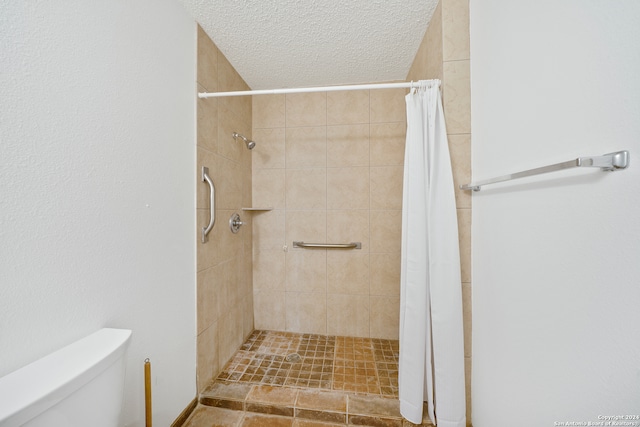 bathroom featuring a shower with curtain, a textured ceiling, and toilet