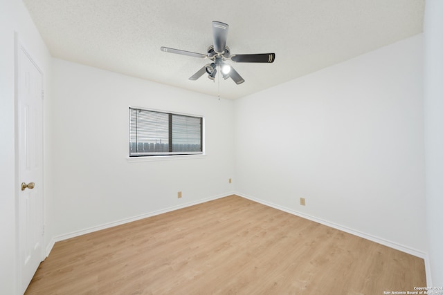 unfurnished room with a textured ceiling, light wood-type flooring, and ceiling fan