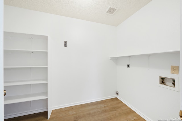 washroom featuring a textured ceiling, hookup for a washing machine, wood-type flooring, and hookup for an electric dryer