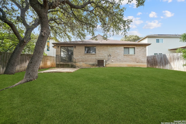 back of house featuring a lawn and a patio area