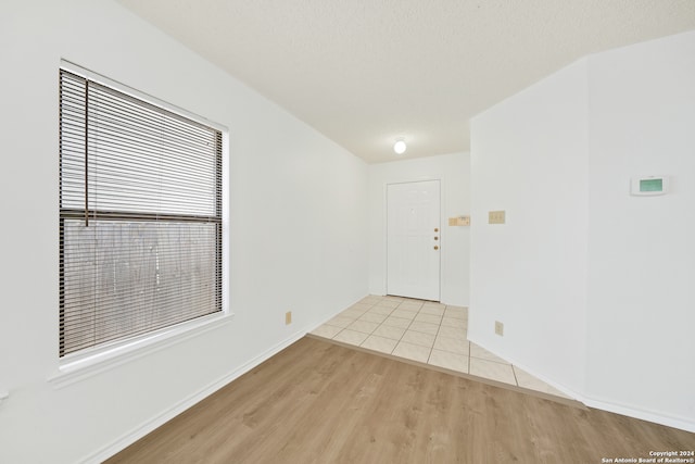 empty room featuring a textured ceiling and light wood-type flooring