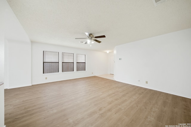 unfurnished room featuring hardwood / wood-style floors, ceiling fan, and a textured ceiling