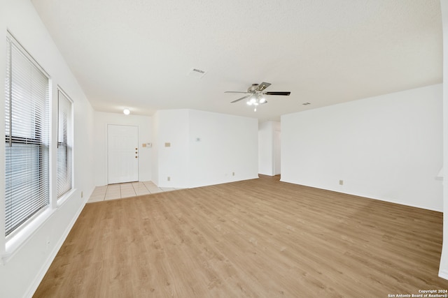 unfurnished living room with light wood-type flooring and ceiling fan