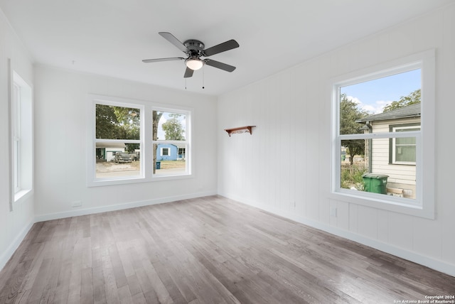 spare room featuring light wood-type flooring, a healthy amount of sunlight, and ceiling fan