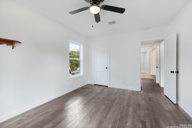 unfurnished bedroom with dark wood-type flooring, ceiling fan, and crown molding