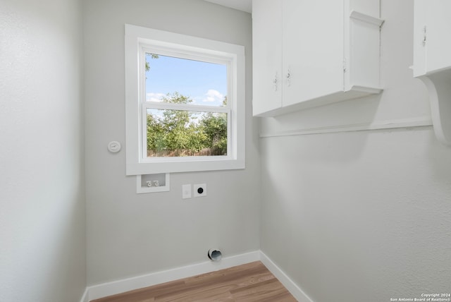 laundry area with cabinets, hookup for a washing machine, electric dryer hookup, and light hardwood / wood-style flooring