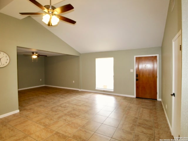 tiled empty room featuring ceiling fan and high vaulted ceiling