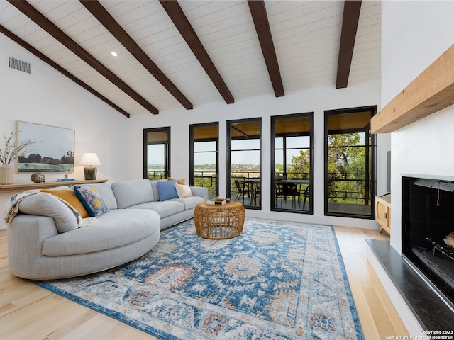 living room with a wealth of natural light, wood-type flooring, beam ceiling, and high vaulted ceiling