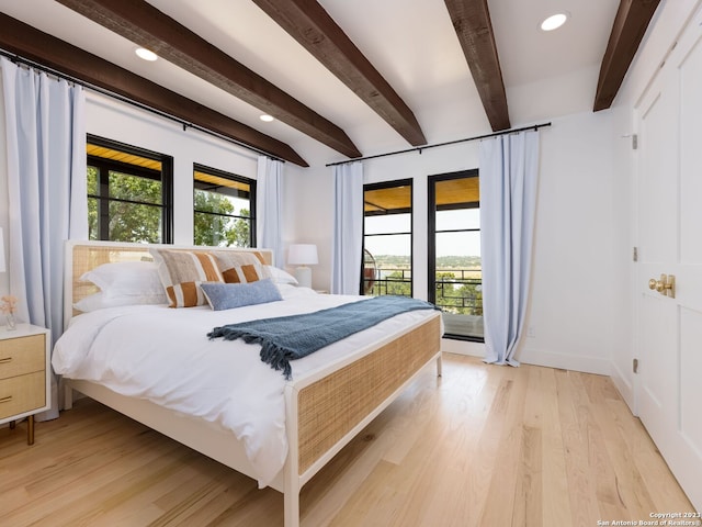 bedroom featuring light hardwood / wood-style floors and beamed ceiling