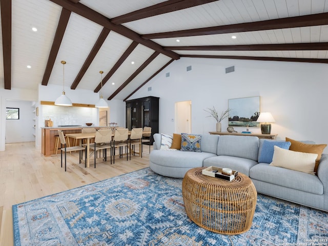 living room featuring high vaulted ceiling, light hardwood / wood-style flooring, and beam ceiling