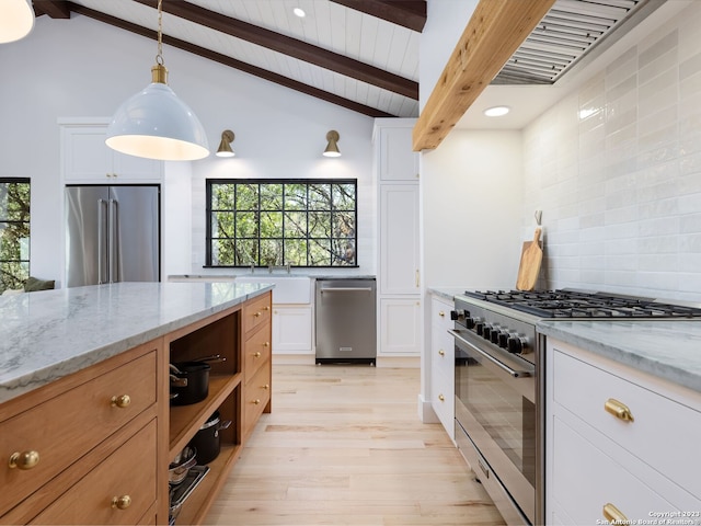 kitchen with white cabinets, decorative backsplash, premium appliances, and light stone counters