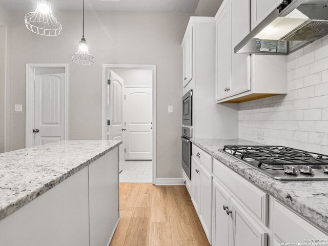 kitchen with pendant lighting, white cabinetry, light wood-type flooring, appliances with stainless steel finishes, and range hood