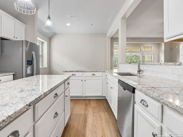 kitchen with stainless steel appliances, sink, hanging light fixtures, white cabinets, and light wood-type flooring