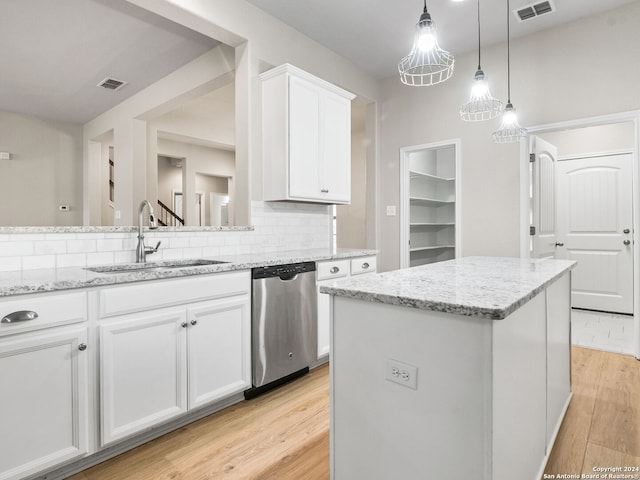 kitchen featuring white cabinetry, sink, light hardwood / wood-style floors, stainless steel dishwasher, and a center island