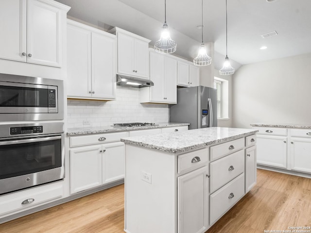 kitchen featuring a center island, stainless steel appliances, white cabinetry, hanging light fixtures, and light hardwood / wood-style flooring