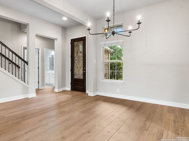 foyer with light hardwood / wood-style floors and an inviting chandelier