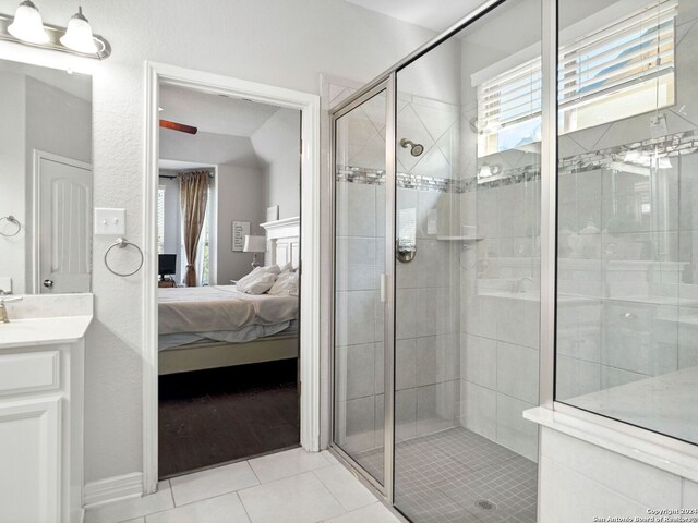 bathroom with walk in shower, vanity, and tile patterned floors