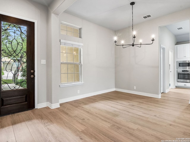 foyer featuring light hardwood / wood-style flooring and a chandelier