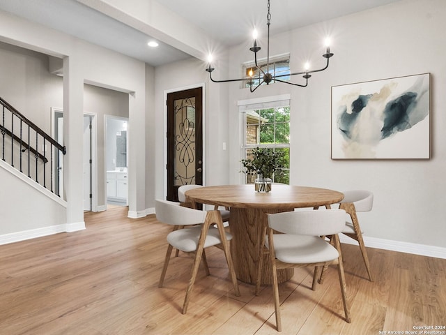 dining area with light wood-type flooring and a chandelier