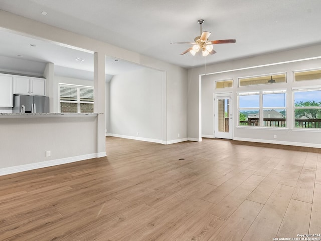 unfurnished living room with light hardwood / wood-style floors and ceiling fan