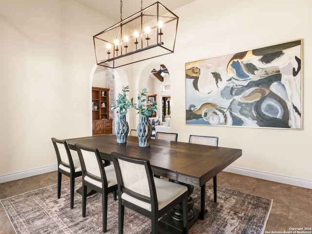 dining area featuring a towering ceiling and ceiling fan