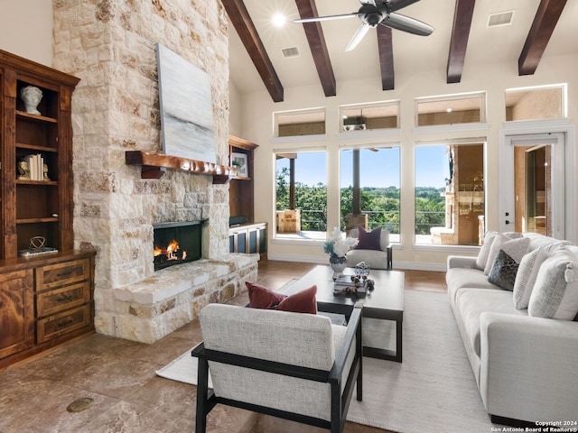 living room featuring a stone fireplace, a towering ceiling, and beam ceiling