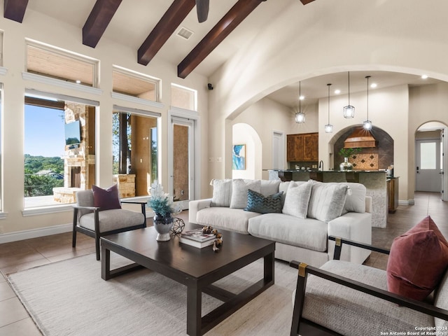 living room featuring high vaulted ceiling, beamed ceiling, and light tile patterned flooring