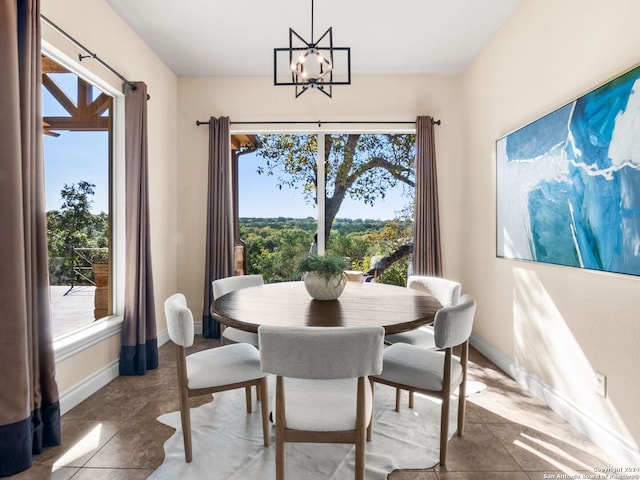 dining room with tile patterned flooring, a healthy amount of sunlight, and a chandelier