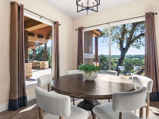 tiled dining space featuring plenty of natural light and an inviting chandelier