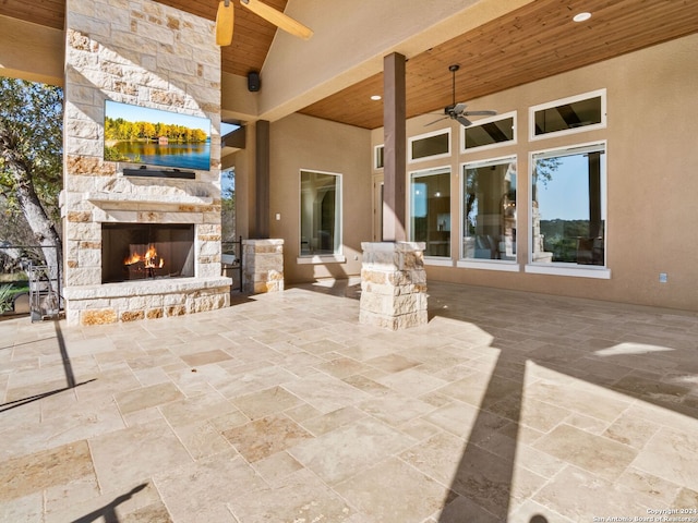 view of patio / terrace featuring ceiling fan and an outdoor stone fireplace