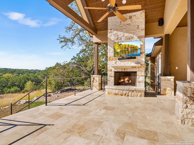 view of patio / terrace with ceiling fan and an outdoor stone fireplace