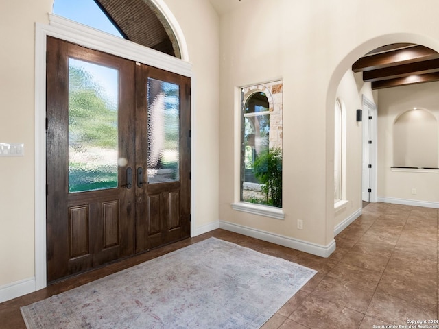 tiled entryway with french doors and beam ceiling