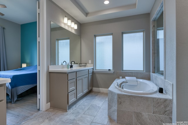 bathroom featuring vanity, hardwood / wood-style flooring, and a relaxing tiled tub