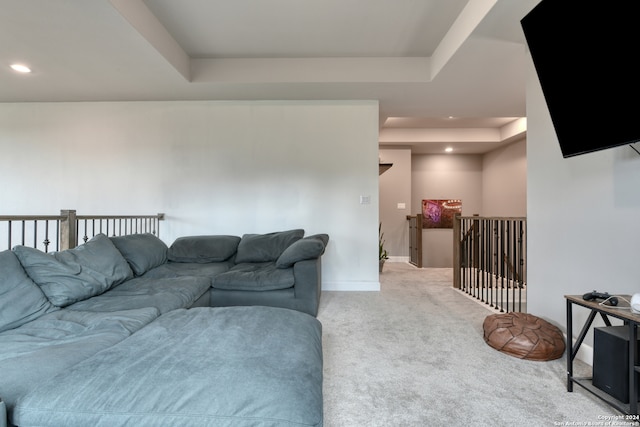 carpeted living room with a tray ceiling