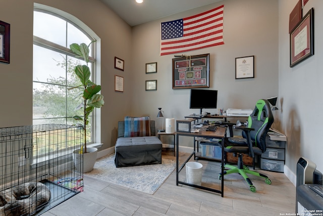 office with a towering ceiling and light hardwood / wood-style flooring