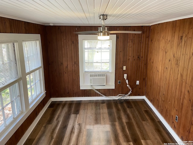 unfurnished dining area with crown molding, wooden walls, dark hardwood / wood-style floors, and cooling unit