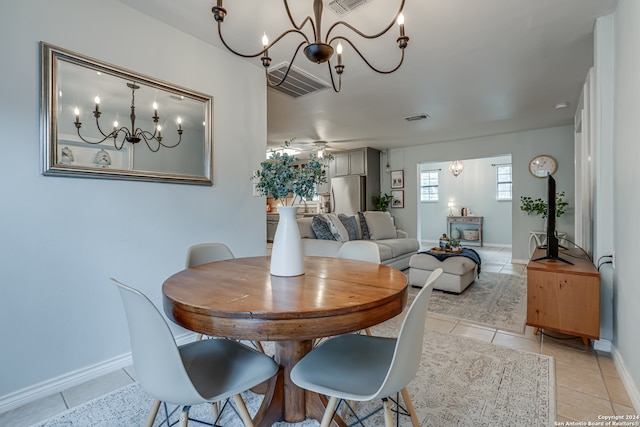 tiled dining space with ceiling fan with notable chandelier
