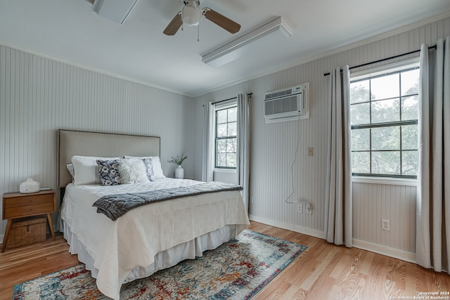 bedroom featuring ceiling fan, multiple windows, light hardwood / wood-style flooring, and crown molding