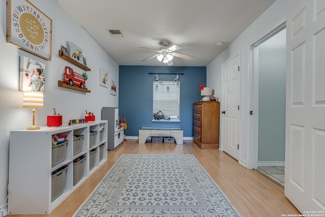 recreation room with ceiling fan and light hardwood / wood-style flooring