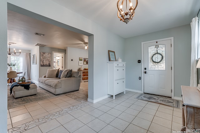 tiled entryway with ceiling fan with notable chandelier