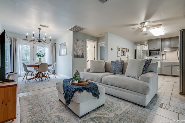 living room with light tile patterned floors and ceiling fan with notable chandelier