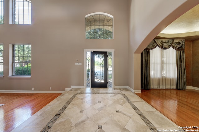 foyer entrance featuring hardwood / wood-style flooring and a high ceiling