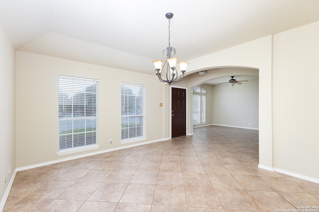 tiled spare room with ceiling fan with notable chandelier