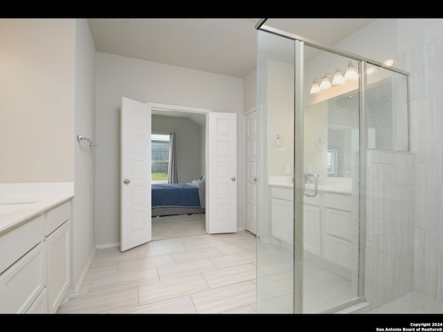 bathroom with a shower with shower door and vanity