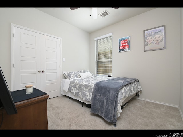 carpeted bedroom with ceiling fan and a closet