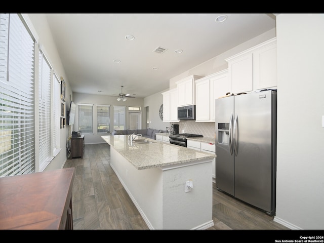 kitchen featuring light stone counters, white cabinetry, appliances with stainless steel finishes, dark hardwood / wood-style floors, and sink