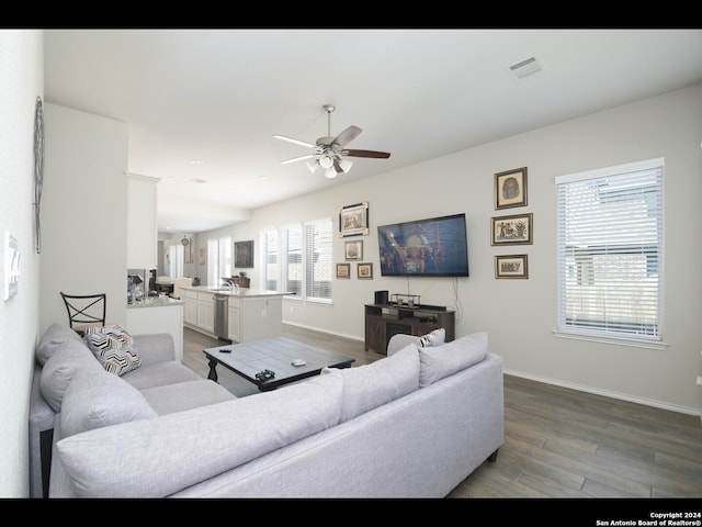 living room featuring wood-type flooring, a healthy amount of sunlight, and ceiling fan